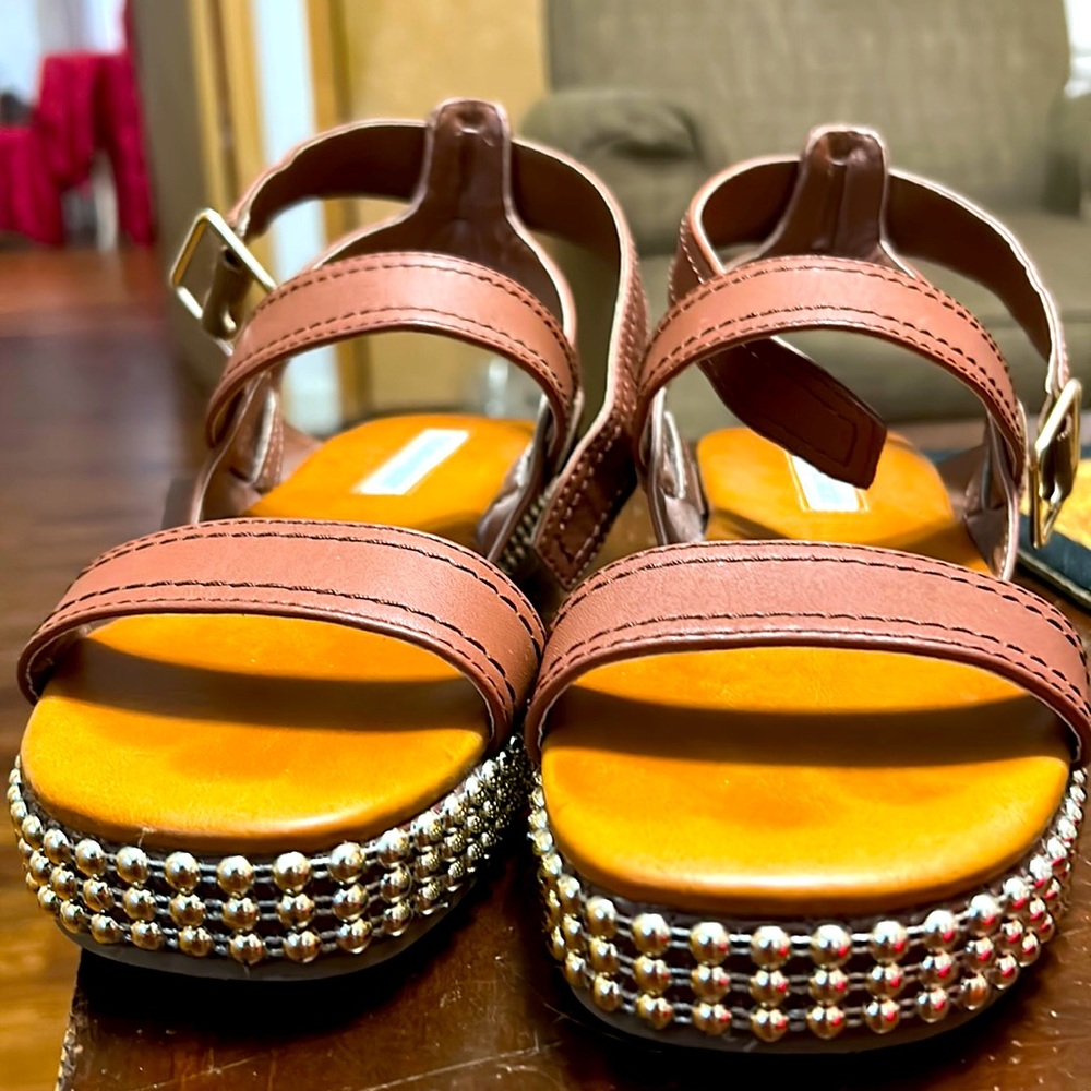 These are brown sandals with beads highlighting the shoe